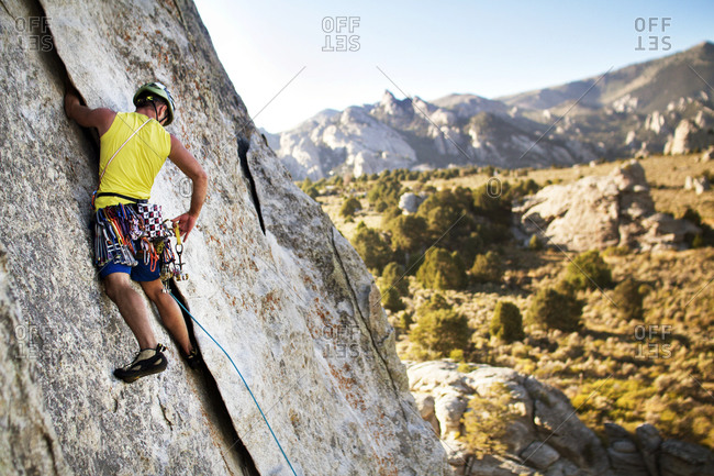 A rock climber reaches for an anchor