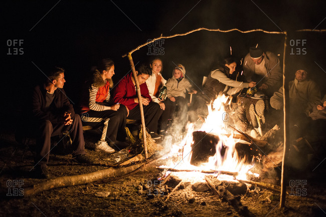 A group of people gather around a fire