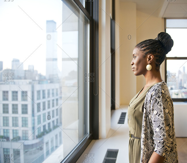 Business woman staring out of an office window