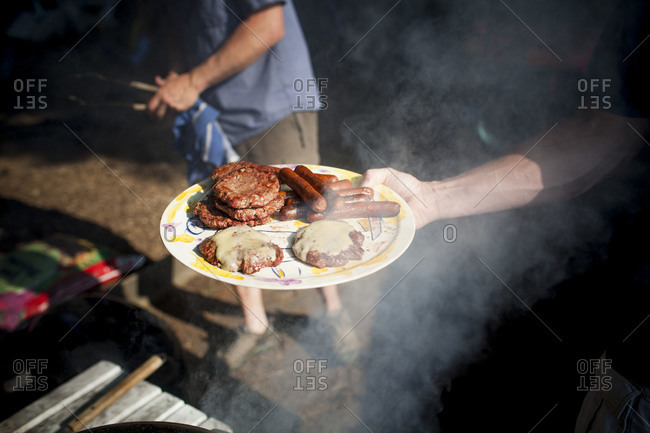Man holding plate of barbecued meats