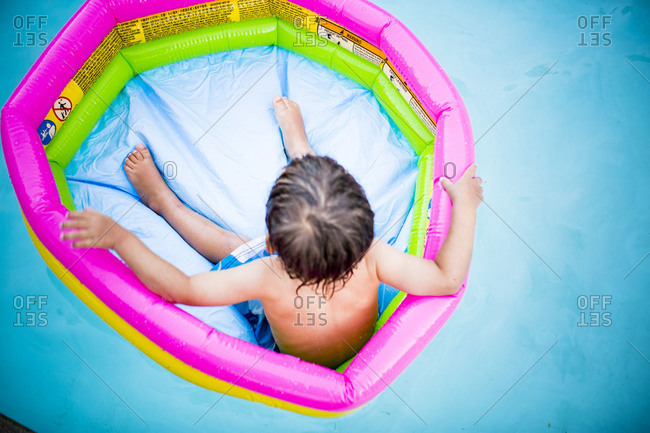 Child floating on a kiddie pool