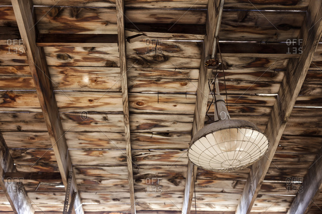 Light fixture hanging from a wooden ceiling