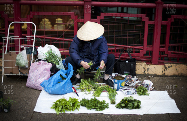 A street vendor sells vegetables on a street in China town in Calgary, Alberta