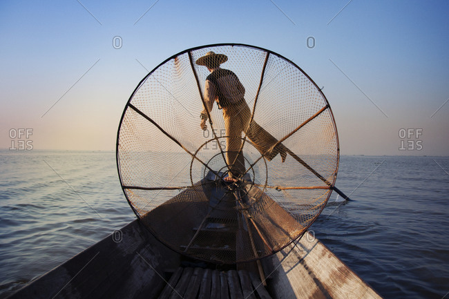A Burmese fisherman on a canoe
