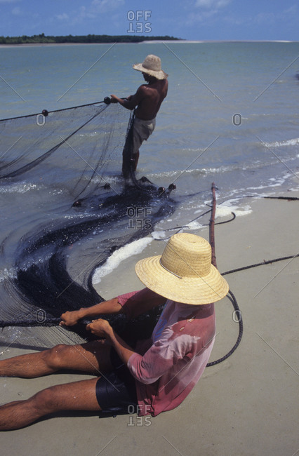 Fishermen casting net in sea
