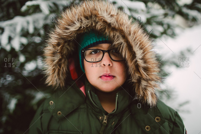 A little boy outside in a fur-lined parka