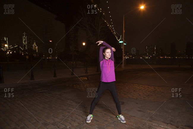 A woman stretches before her evening run