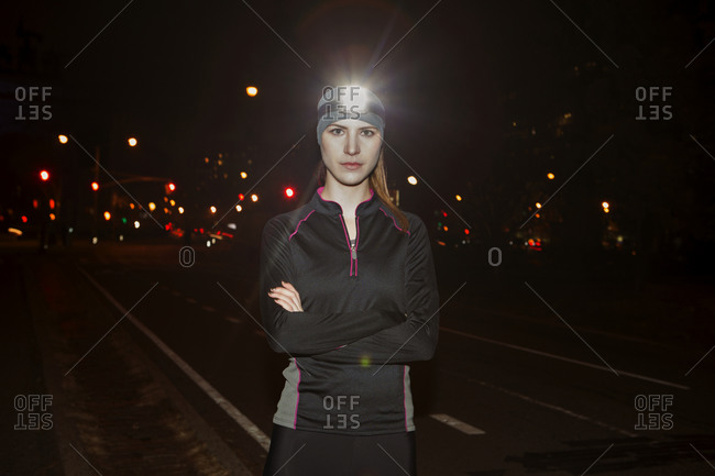 A jogger stands on a city street
