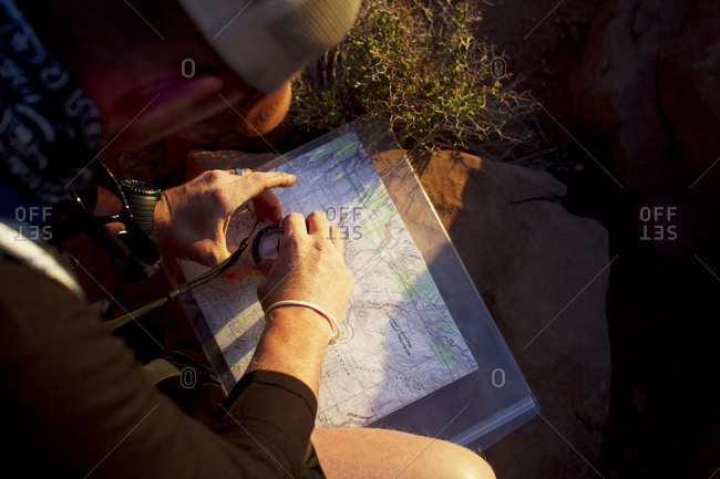 A mountain climber using a map to navigate through the desert