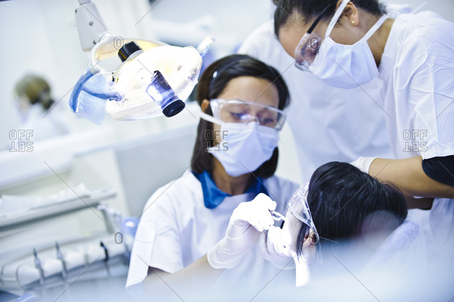 Dentistry students performing dental surgery on a patient