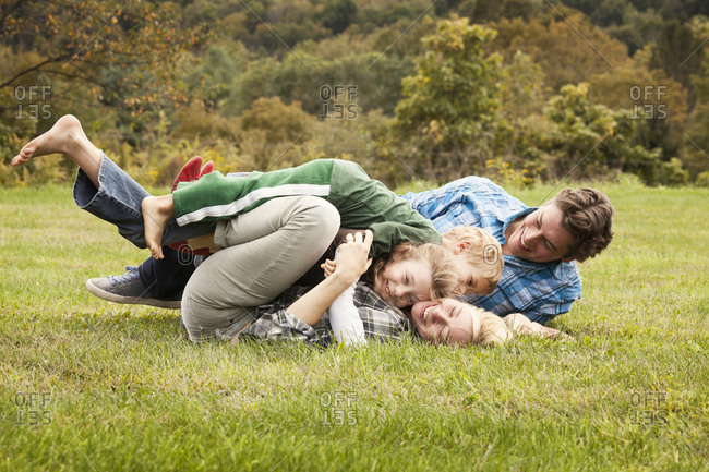 Children wrestling their parents in the grass