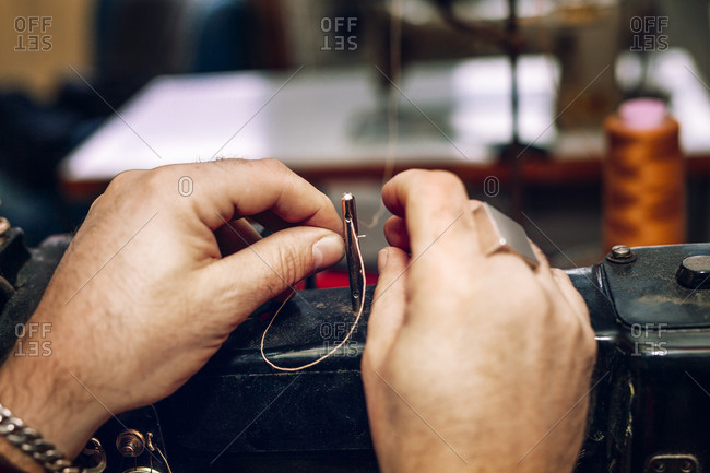 A craftsman threads a sewing machine