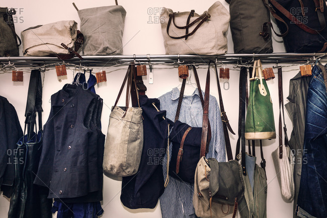 Canvas bags and clothing hanging from a rack