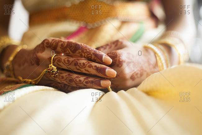 South Asian bride shows off henna designs and rings on hand