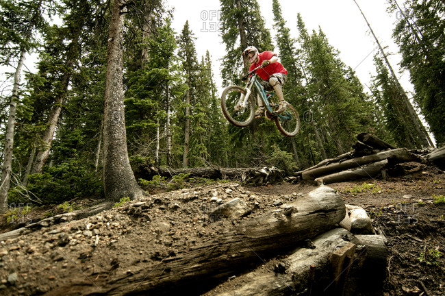 Man jumping with his bike in a forest