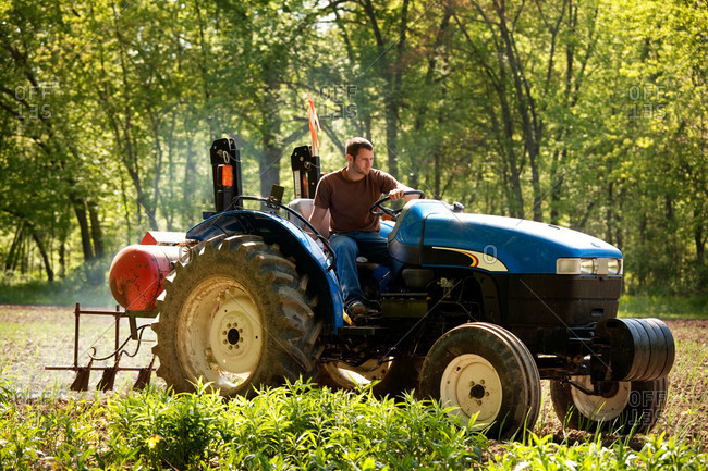A farmhand driving a tractor