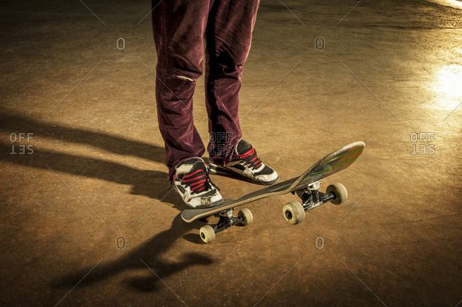 Skateboarder stepping on back of skateboard