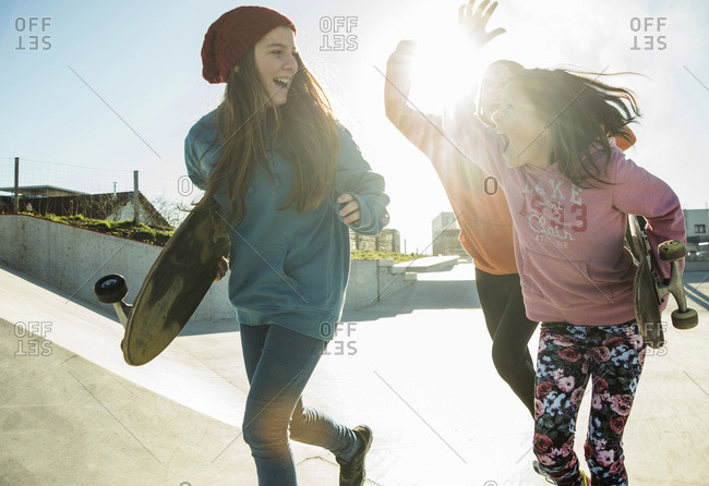 Three girls running in skate park