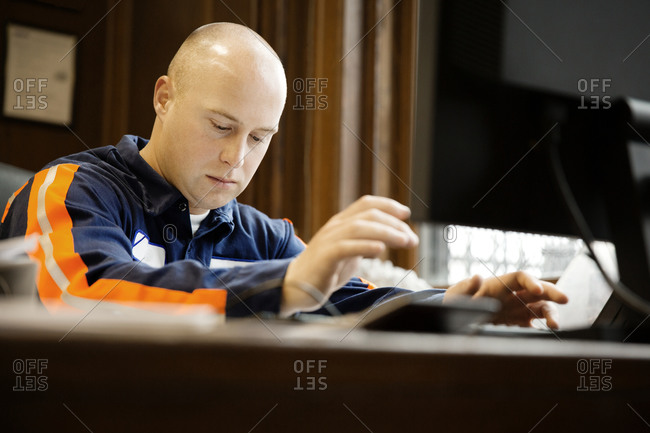 An industrial worker typing notes during a meeting