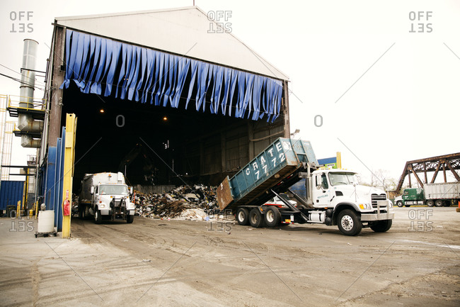 A truck dumps materials at a recycling plant