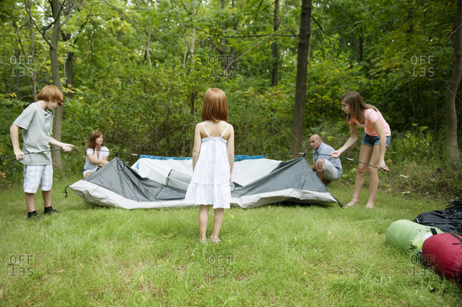 A family sets up a tent together