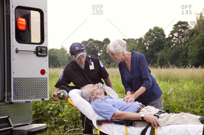 Emergency medical technician with elderly man on gurney