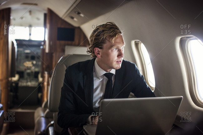 Businessman with laptop on private jet