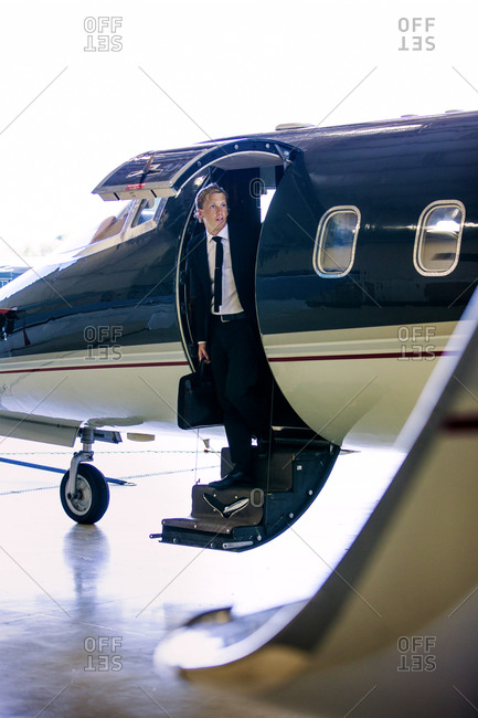 Businessman stepping out of private jet