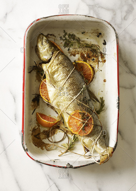 Cooked whole fish in pan with citrus