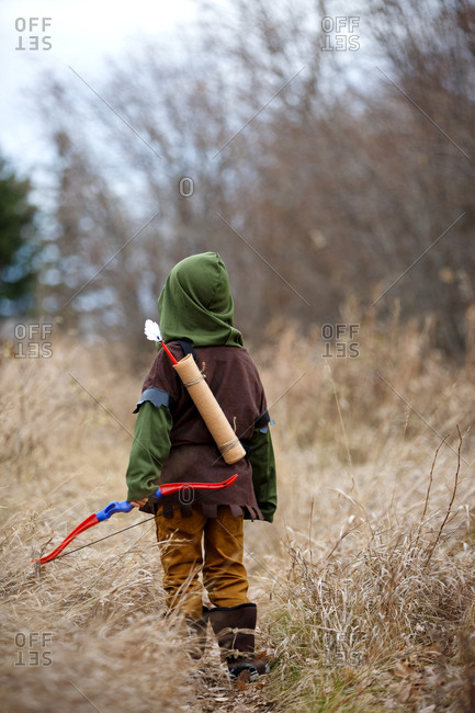 Boy in Robin Hood costume outside from behind