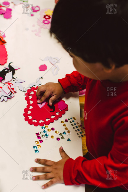 A little boy works on a Valentine\'s Day project