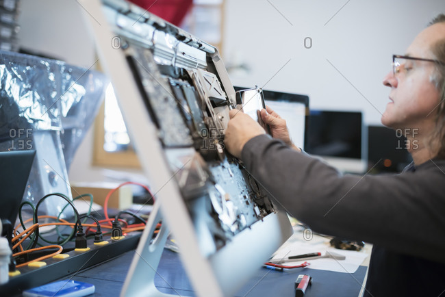 Man taking apart computer monitor to fix it