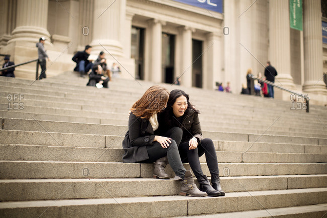 Friends laughing on the steps of a museum