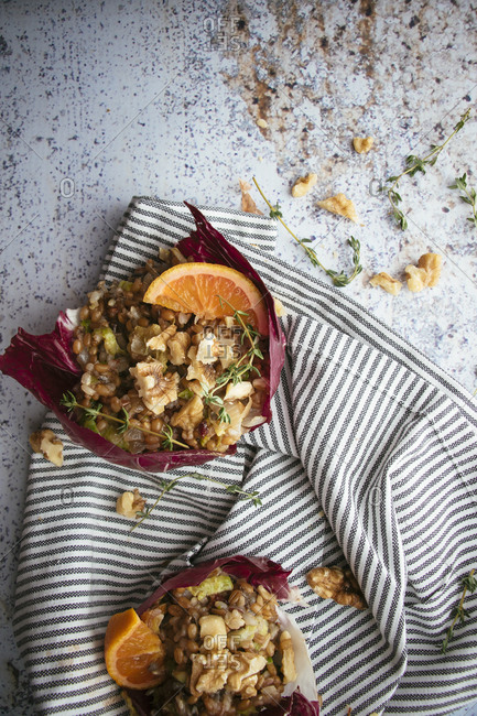 Overhead view of two wheatberry winter salads with walnuts and slices of oranges
