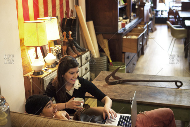 Couple watching a laptop in a hip coffee shop