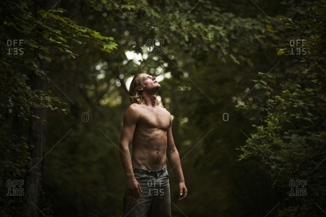 Shirtless Man In Woods Looking Up At Sky Stock Photo Offset