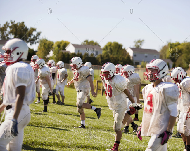 A high school football team leaves the field