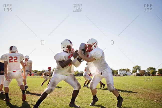 Two high school football players blocking