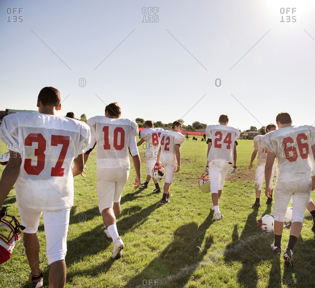 A high school football team walks onto the field