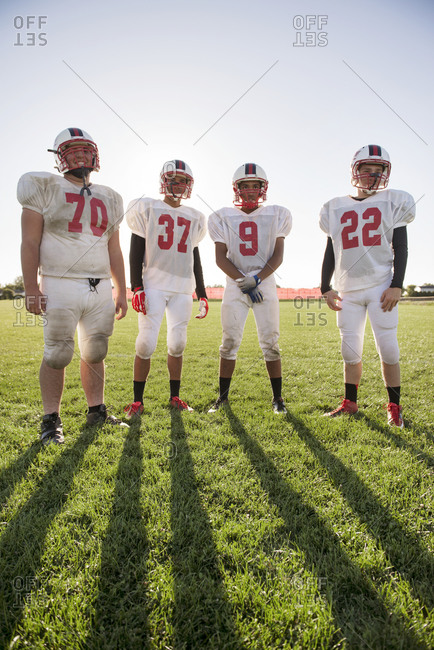 Four high school football players on a field