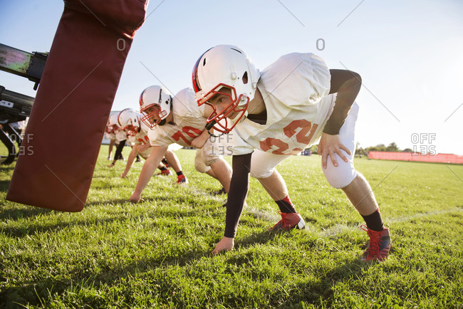 High school football players prepare to tackle a dummy