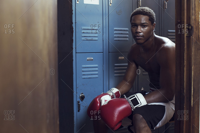 Young athlete sitting in locker room before boxing match