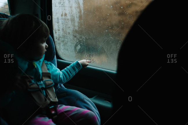 Young girl staring out of a car window