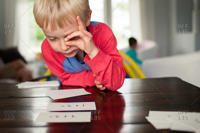 Young boy staring at flash cards on a table