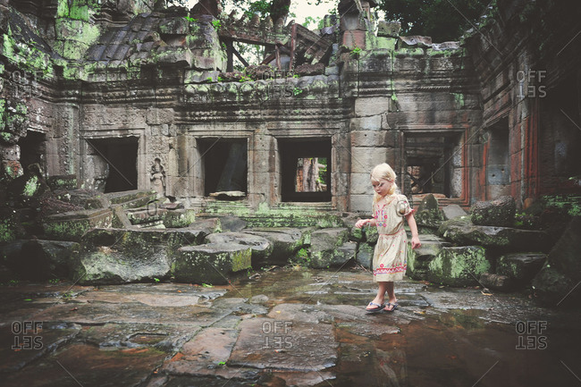 Little girl playing in ancient temple ruins