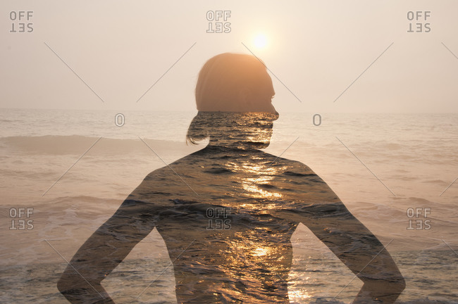 Outline of woman\'s silhouette against beach sunset