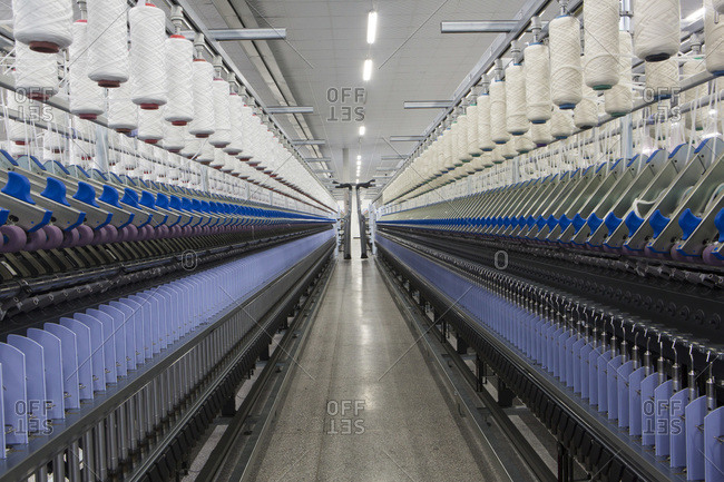 Machines in factory spinning wool into thread