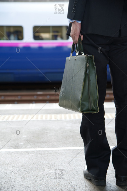 Business man waiting for a commuter train in Tokyo, Japan