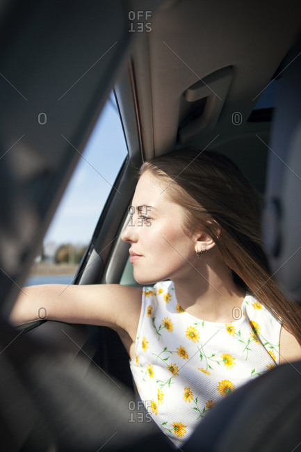 Blonde woman staring out of a car window