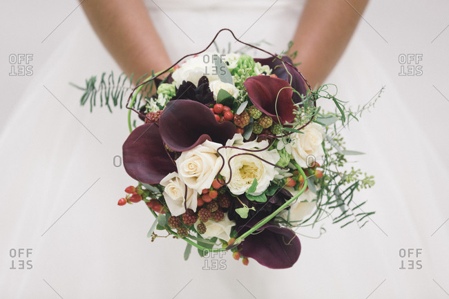 Close-up of a bridal bouquet with berries and calla lilies